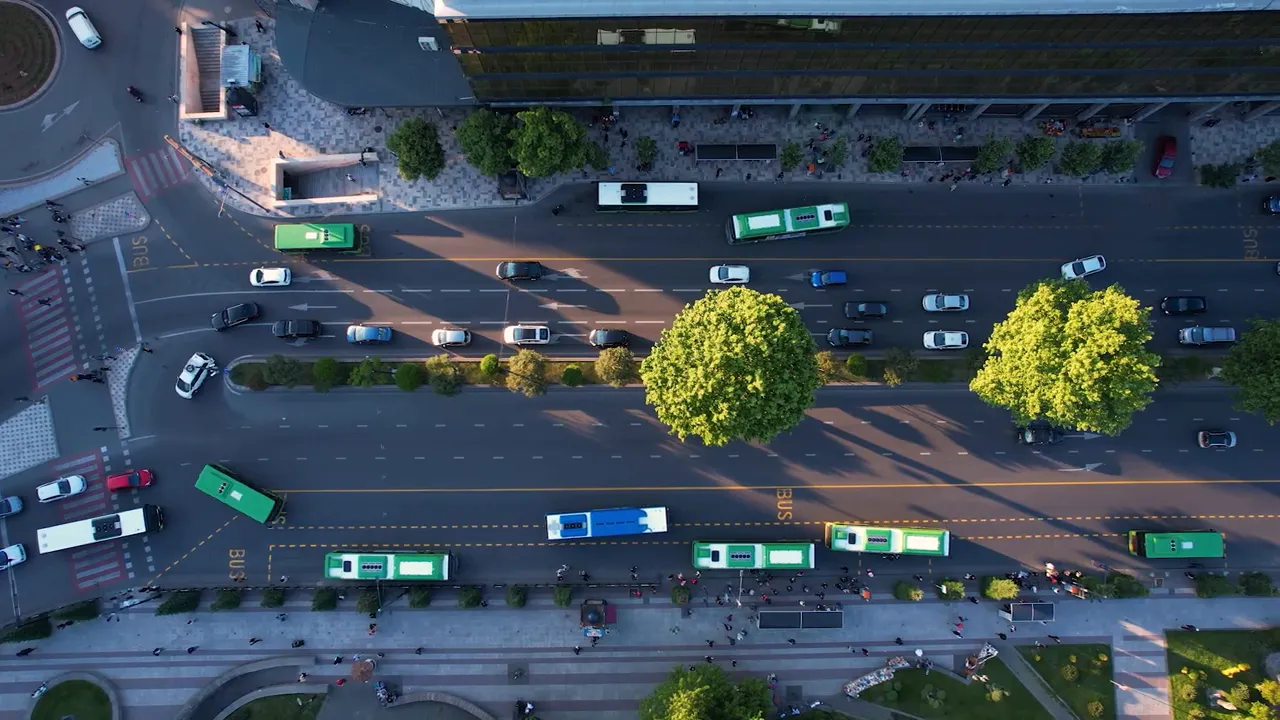 Aerial view of multiple city buses traveling on a downtown street