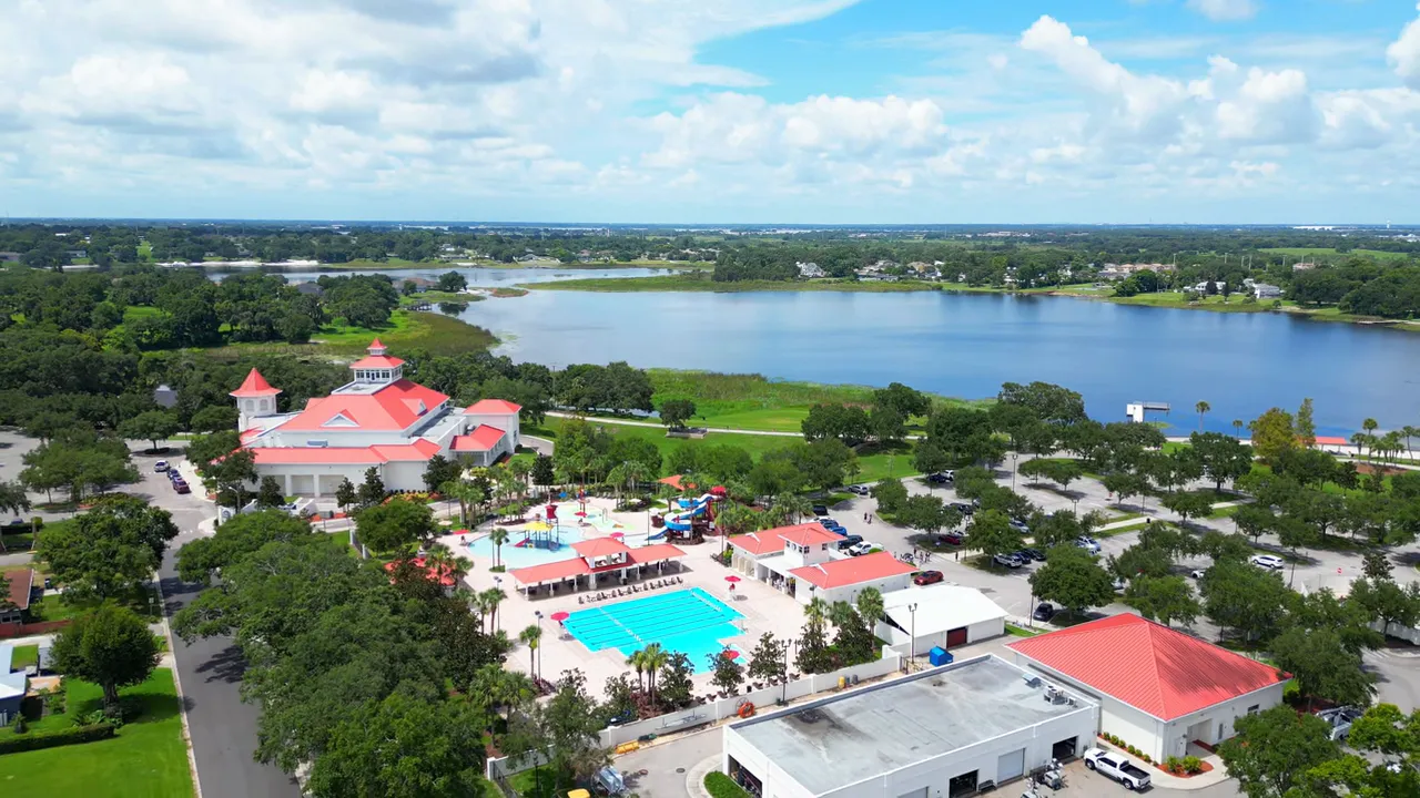 Aerial view of Lake Eva Community Park showing swimming pools, splash pad, event building and Lake Eva