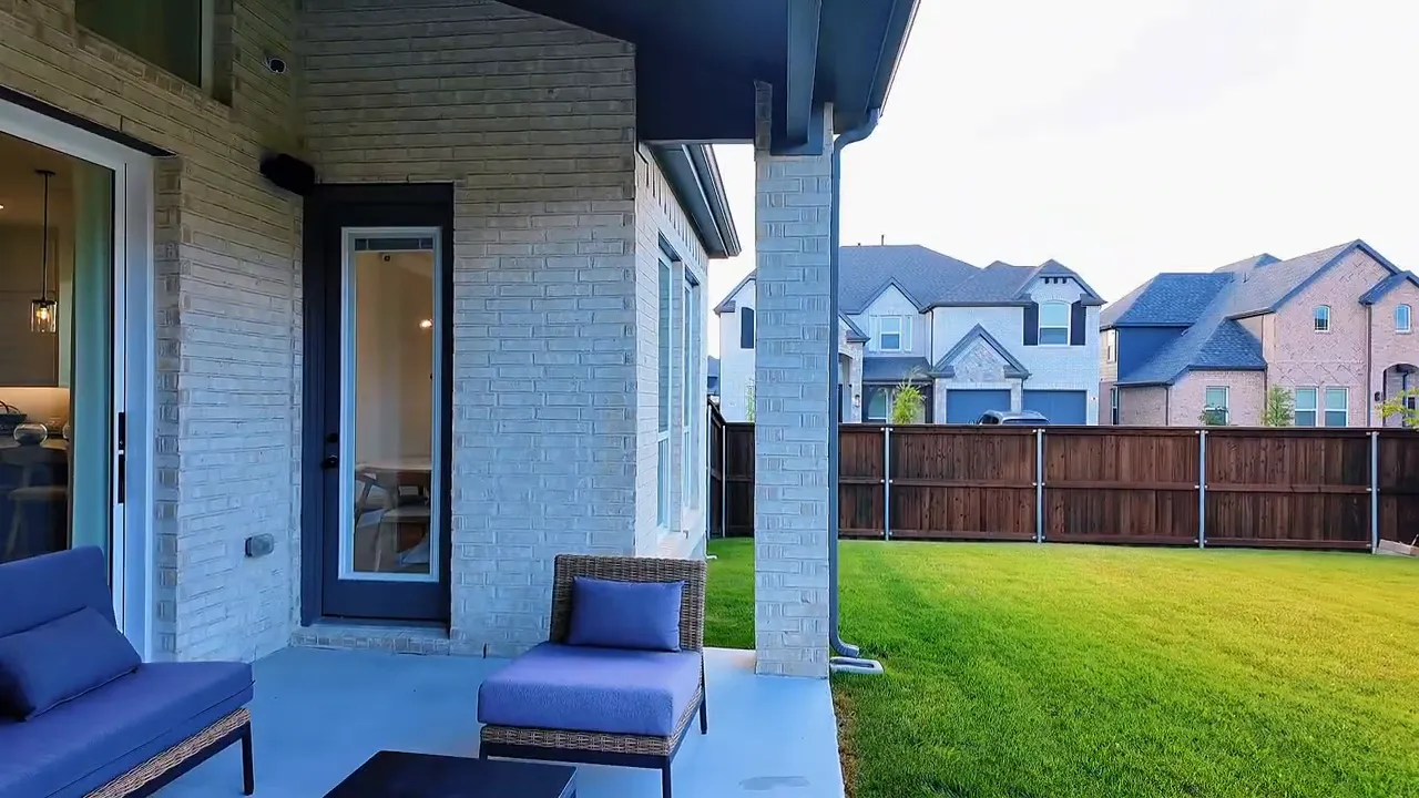 Covered patio and backyard seating area outside a new construction home in Forney, Texas