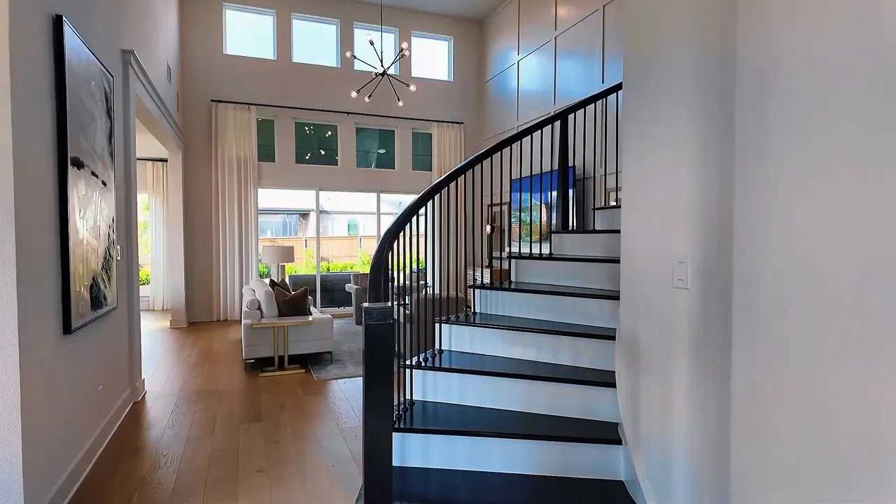 Curved staircase inside a Forney TX new construction home with open floor plan view