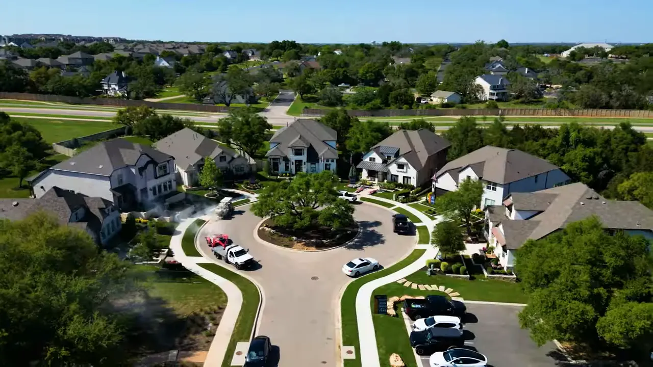 Drone aerial of a suburban cul-de-sac with a variety of single-family homes, yards and street layout