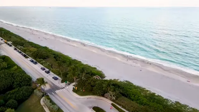 Top-down aerial view of turquoise ocean waves meeting a wide sandy beach