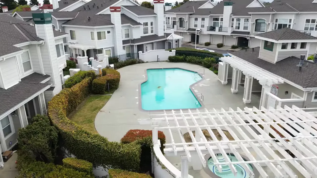 community pool surrounded by townhomes and landscaped walkways