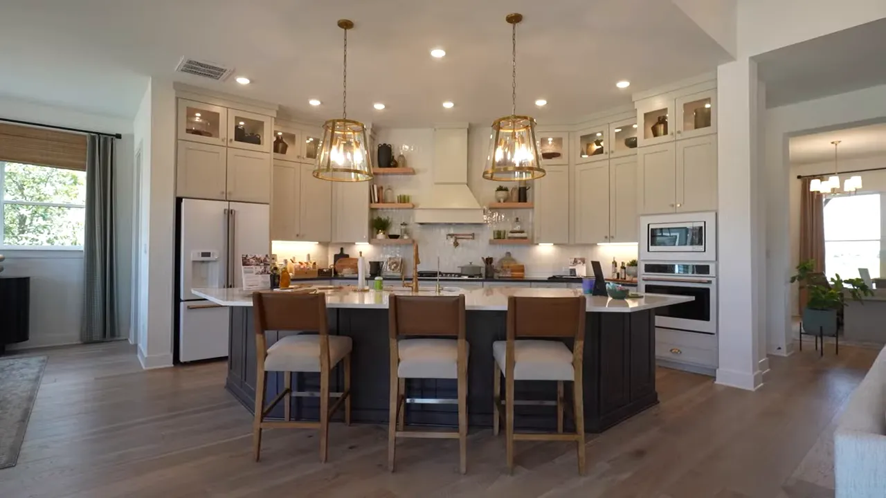 Open kitchen with long island dining area and wood ceiling beams