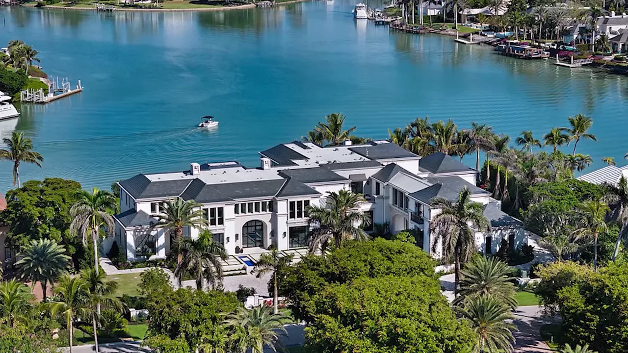 Aerial view of a large luxury waterfront estate with private dockage and tropical landscaping near Naples, FL