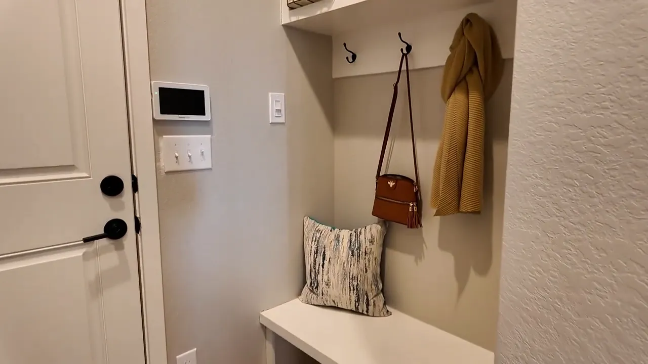 Entry nook with bench, hooks, and organizer area in Painted Prairie Residence 3 model home