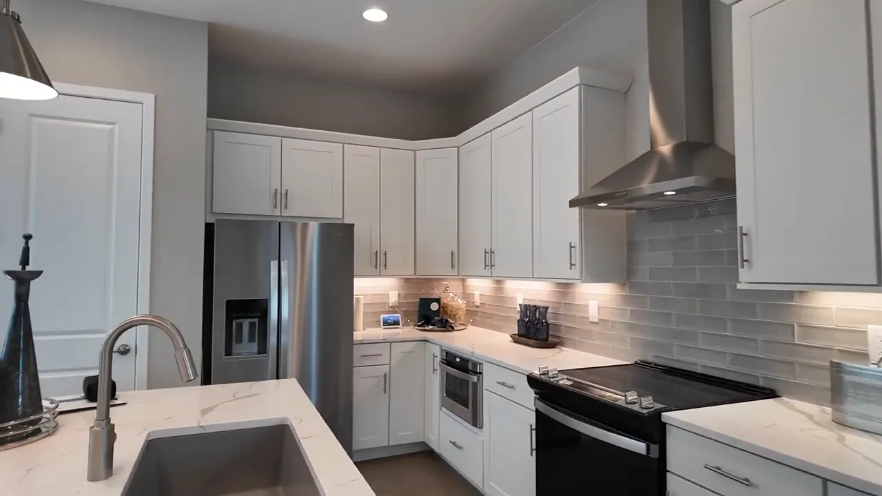 Residence 2 kitchen at Painted Prairie with white cabinets, central island, and built-in oven and range