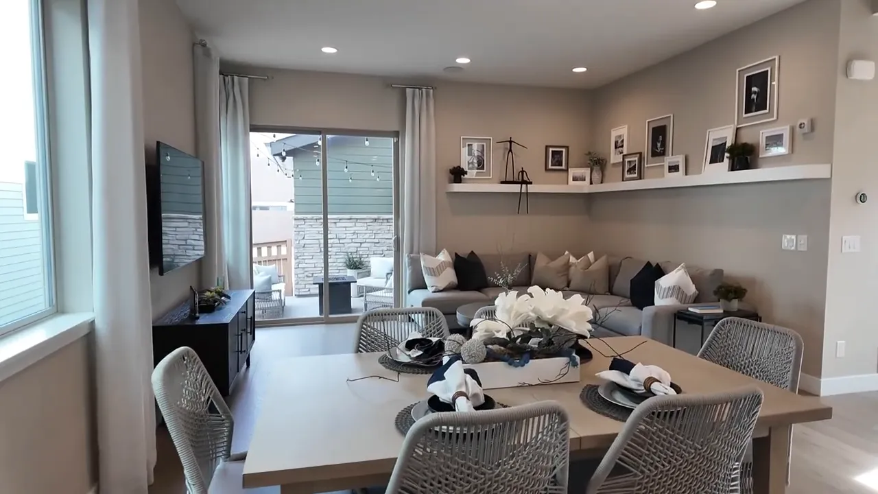 Residence 2 model home dining table view showing living room seating and outdoor patio doors