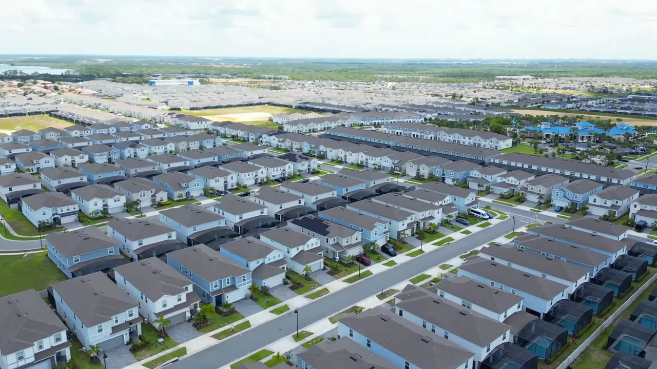 Aerial view of suburban neighborhood with rows of new single-family homes in Davenport
