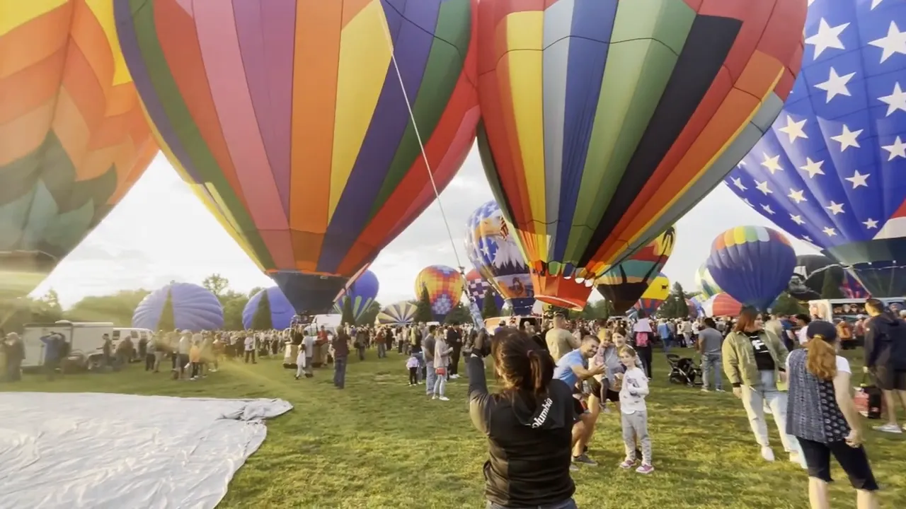 Colorful hot air balloons standing upright in a grassy field