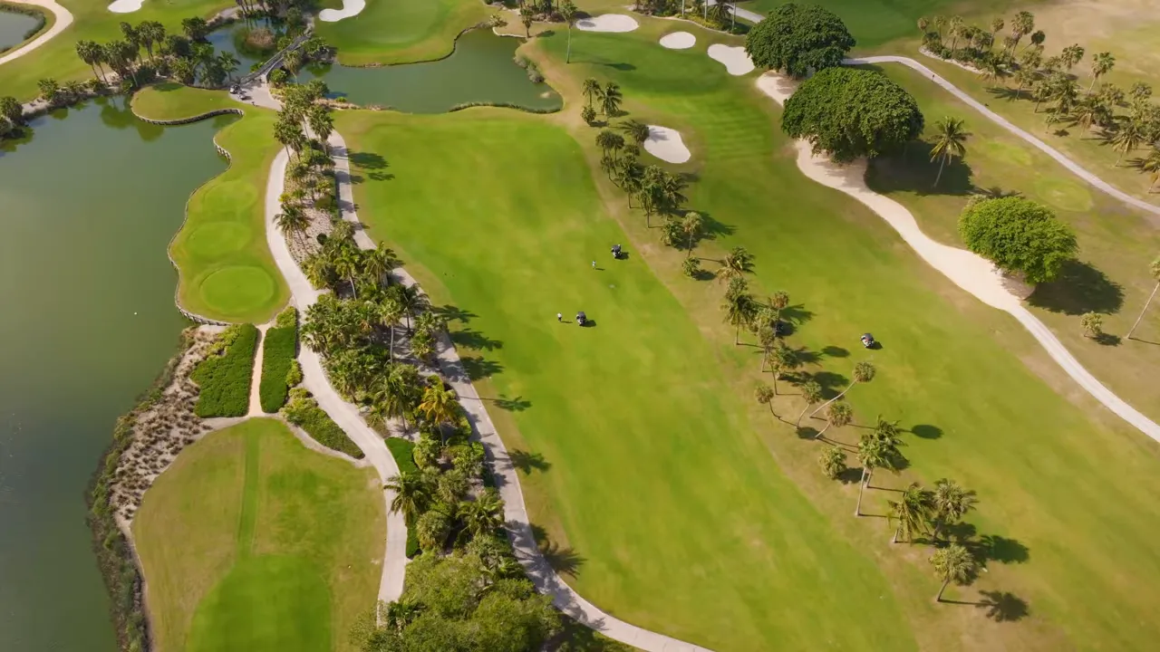 Aerial view of a West Lake Worth golf and lake community with walking paths and open green space