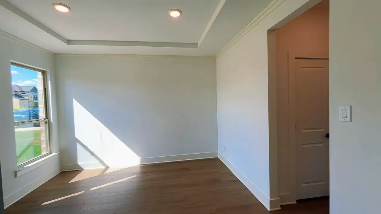 Front flex room with tray ceiling wood floors and two tall windows