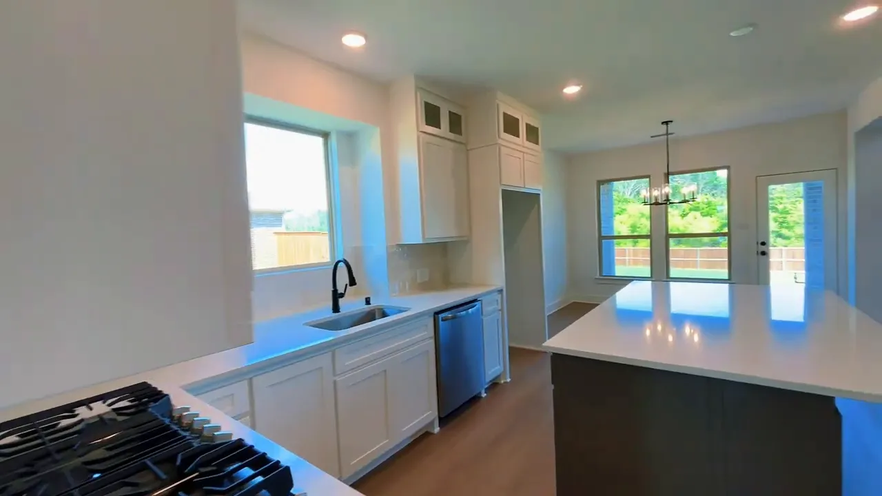 Kitchen view showing sink under window dishwasher large island and breakfast area