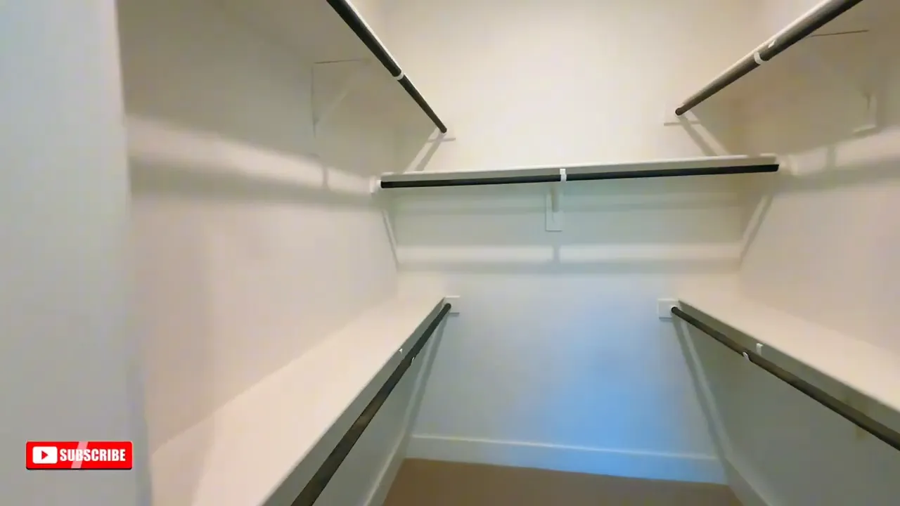 Large walk in closet with shelves and hanging rods on both sides
