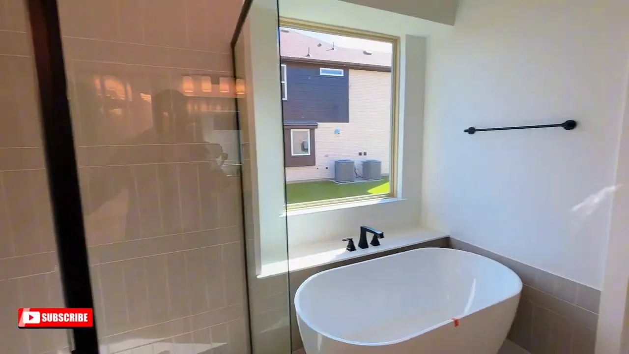 Primary bathroom with glass shower freestanding tub and window