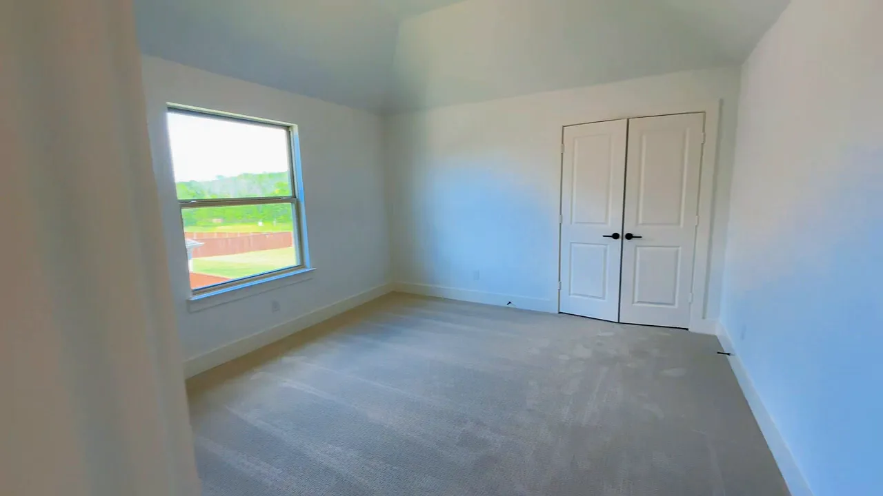 Upstairs bedroom with window carpet and double closet doors
