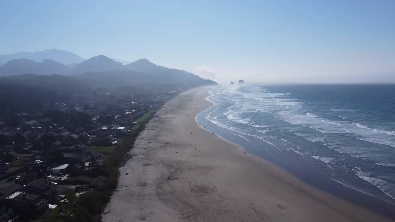 Aerial view of an Oregon Coast beach with waves and surrounding neighborhoods