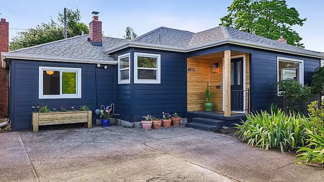 Exterior of a single-level dark blue home with a covered entry