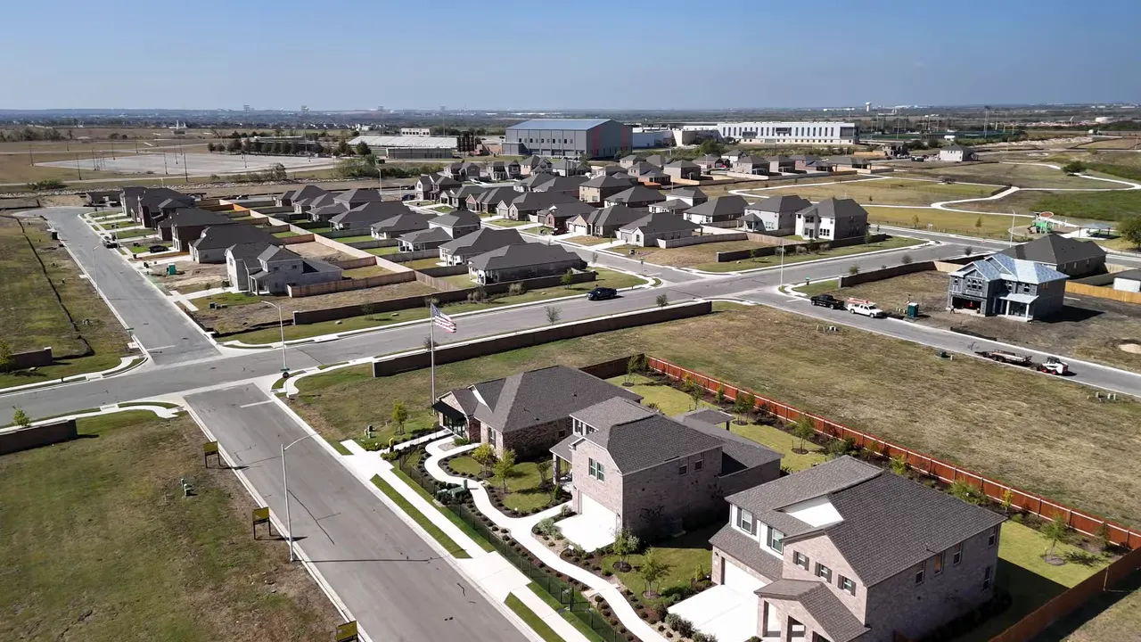 Wide aerial view of a suburban development with new homes and streets