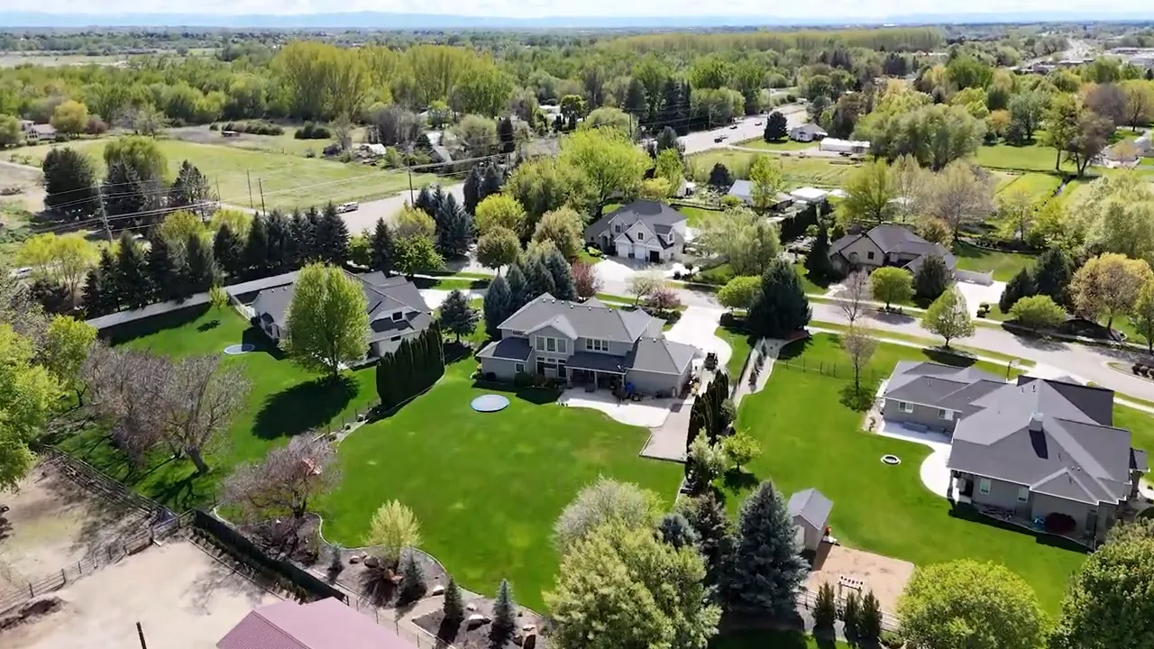 Aerial view of large homes on spacious green lots with a golf course nearby