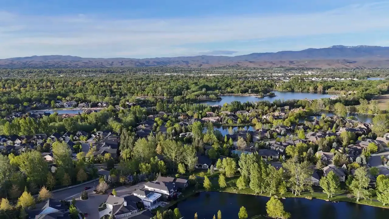 Wide aerial view of Eagle neighborhoods trees lakes and distant foothills