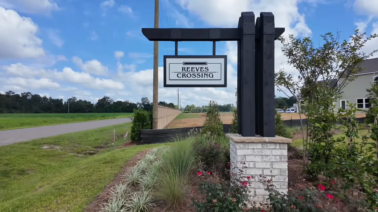 Reeves Crossing community entrance sign with landscaping and blue sky