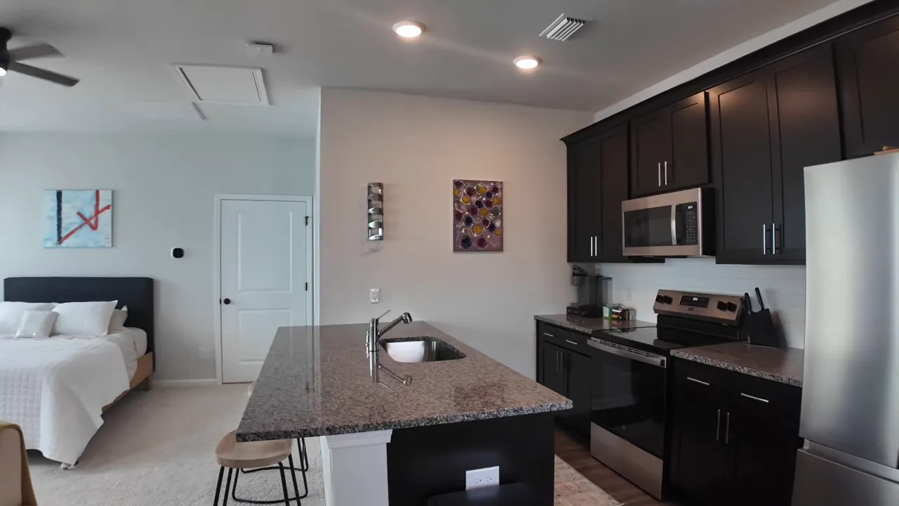 Finished room over garage with kitchen, island, sofa seating, and windows