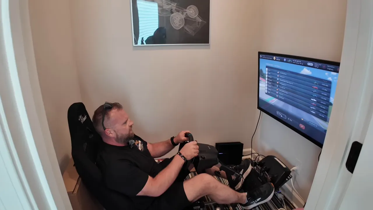Small room with racing simulator seat, steering wheel, pedals, and monitor