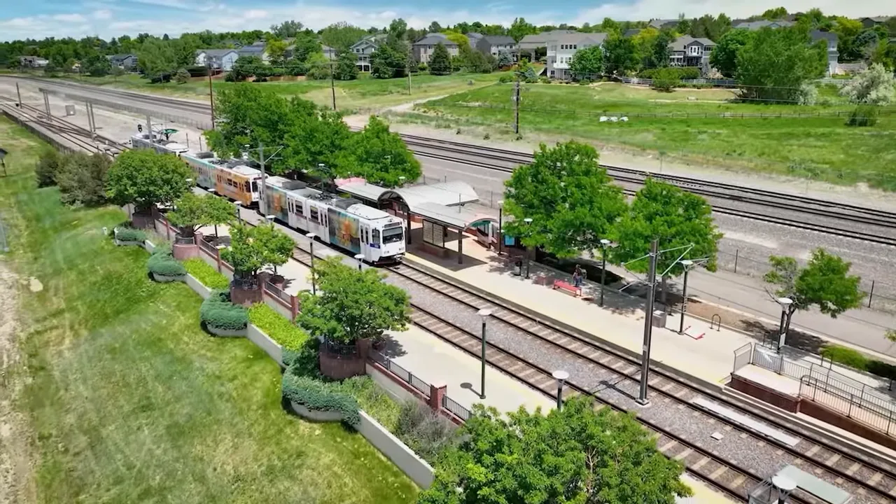 Light rail station and tracks in Littleton Colorado with nearby residential neighborhoods