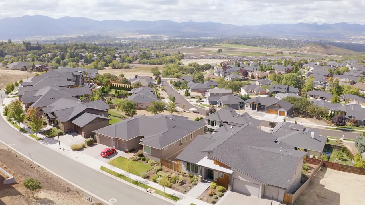 Aerial view of suburban homes and rooftops in Southern Oregon showing yards and street layout