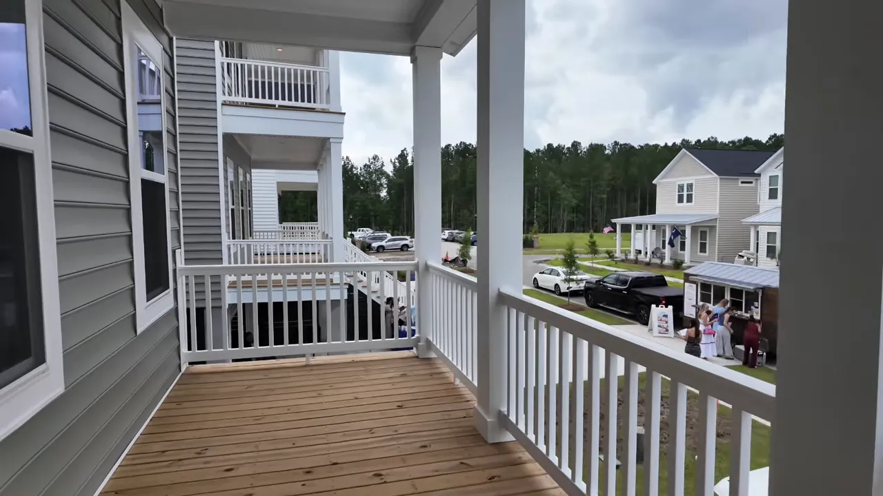 Covered elevated porch overlooking nearby homes and neighborhood street