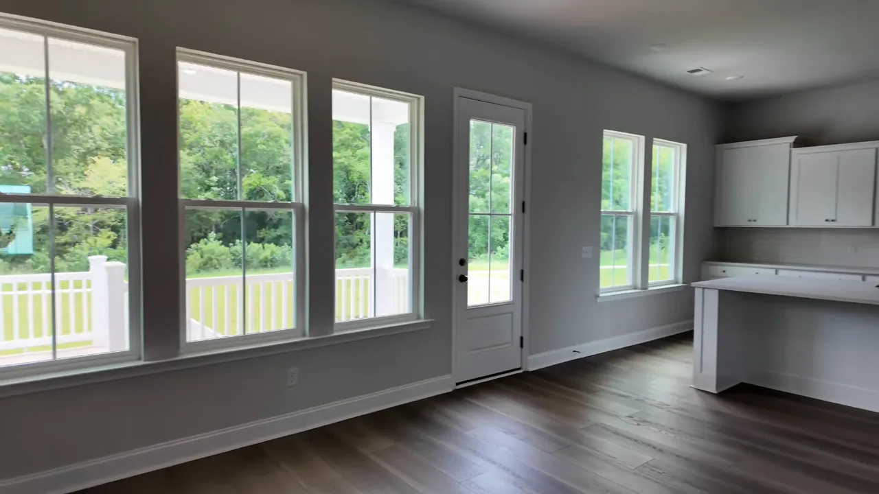Open living room and white kitchen with large island and windows