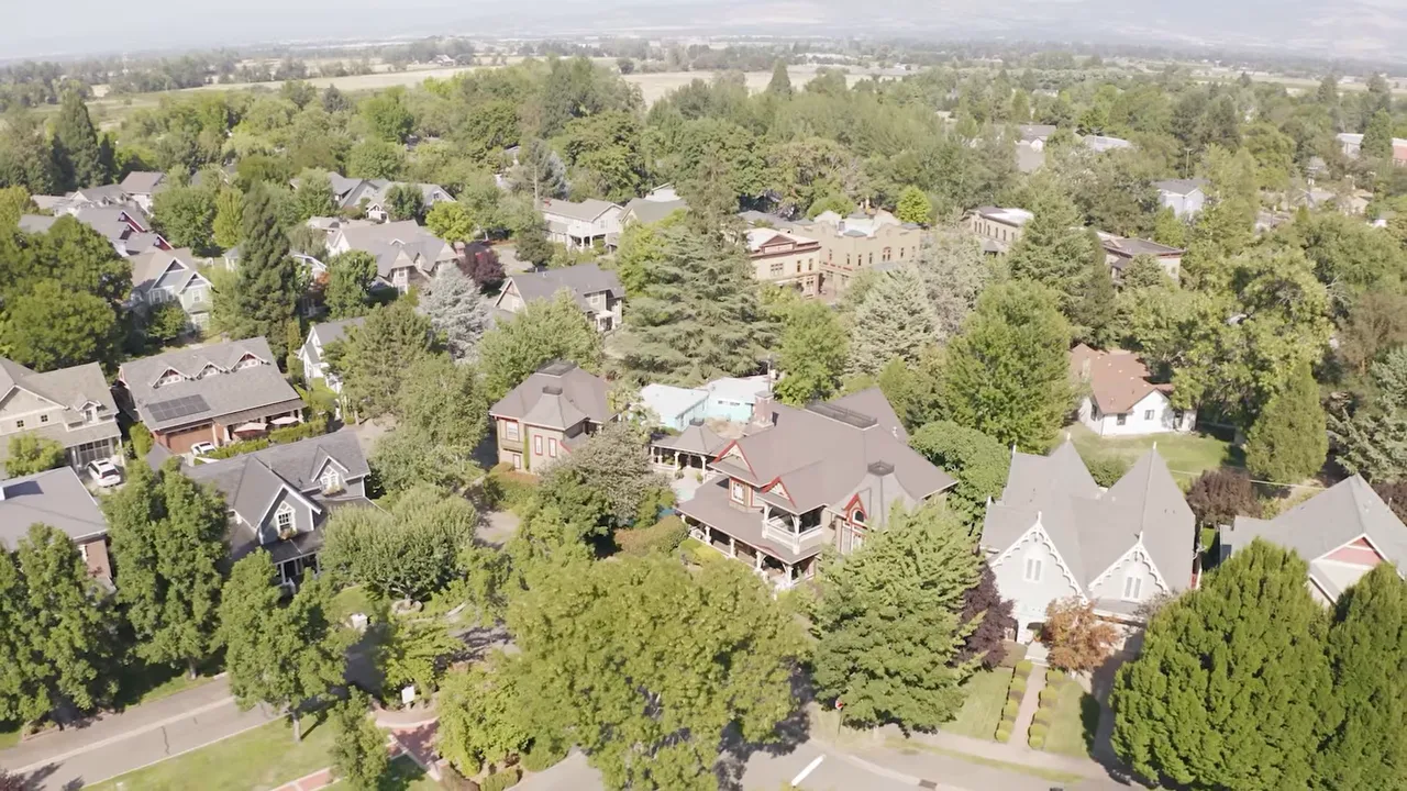Aerial view of a residential neighborhood with houses and trees in Southern Oregon
