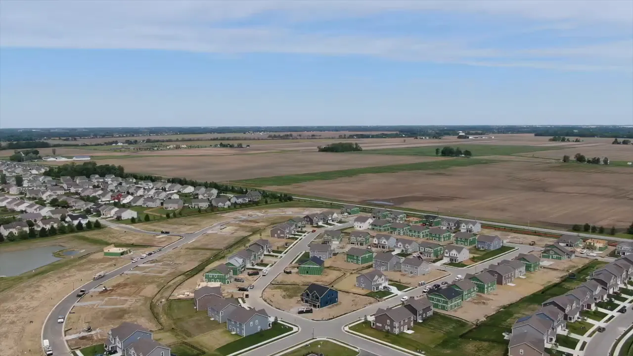 Aerial view of new homes under construction beside farmland