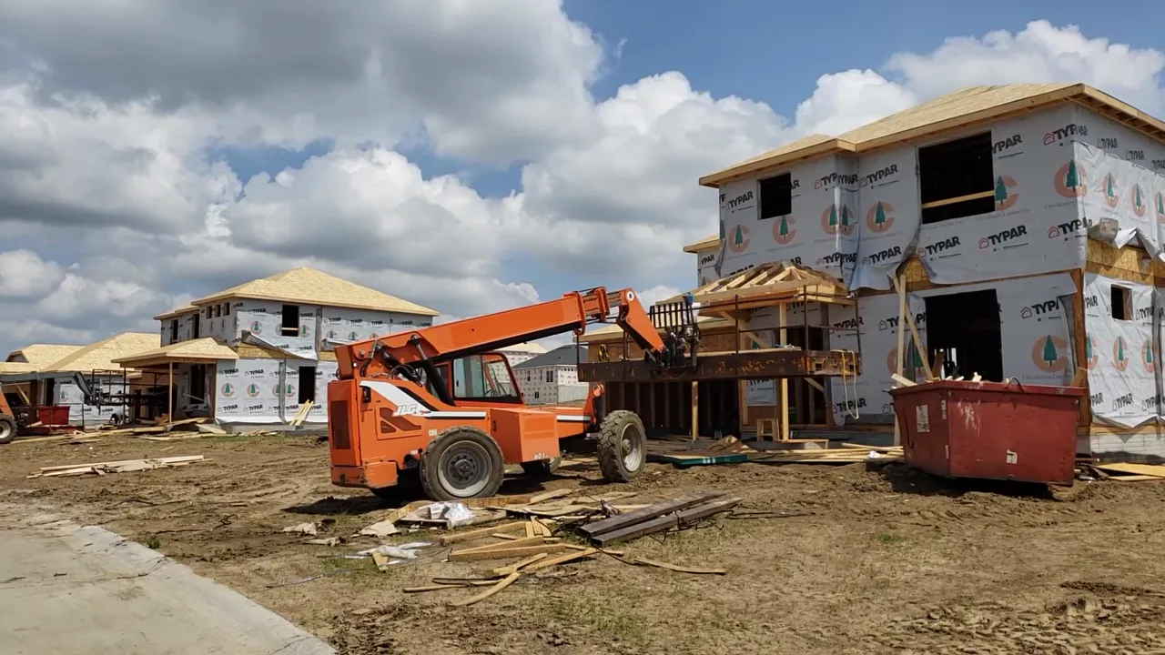 Homes under construction with equipment and building materials on site
