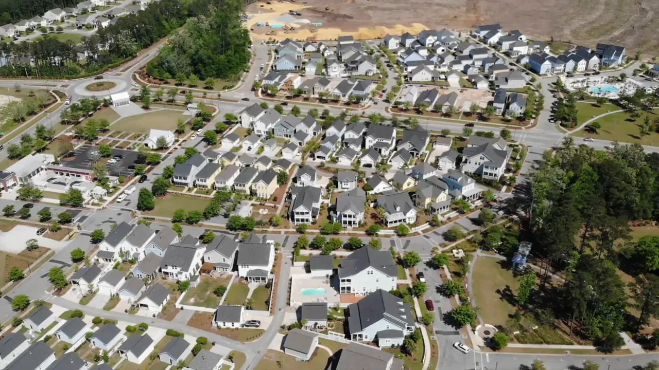 High aerial view of tightly packed homes and surrounding development
