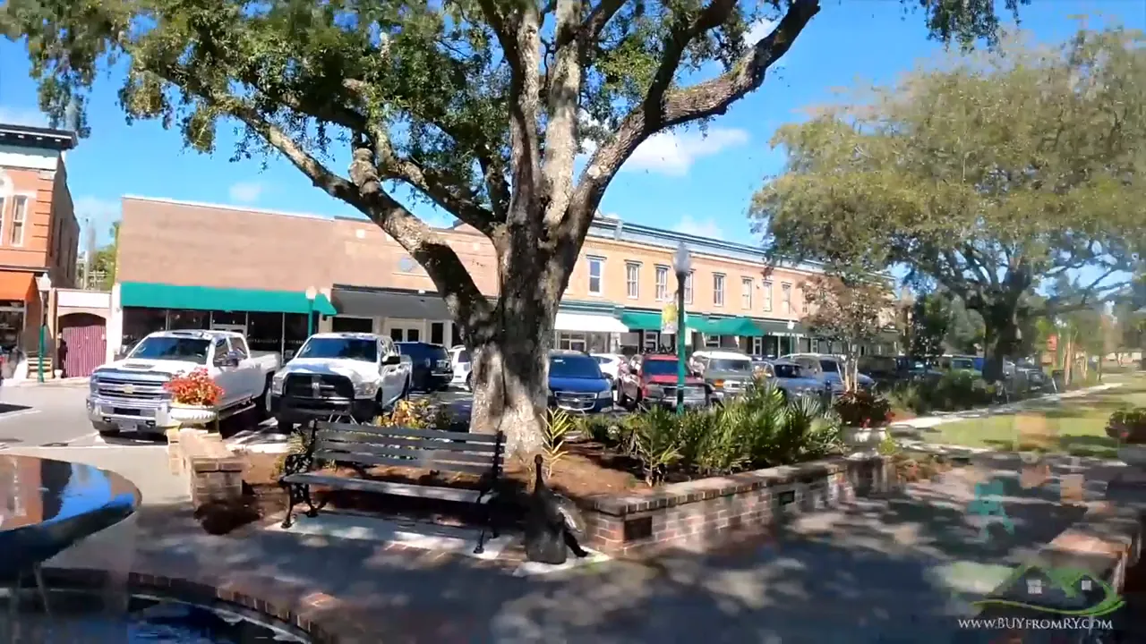 Cars parked along storefronts in a downtown shopping area