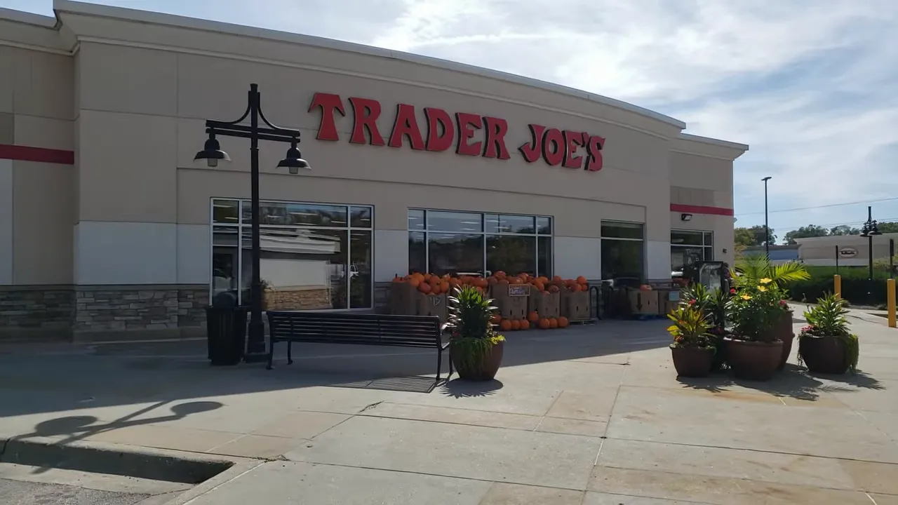Front exterior of a Trader Joe's store with seasonal displays and sidewalk planters