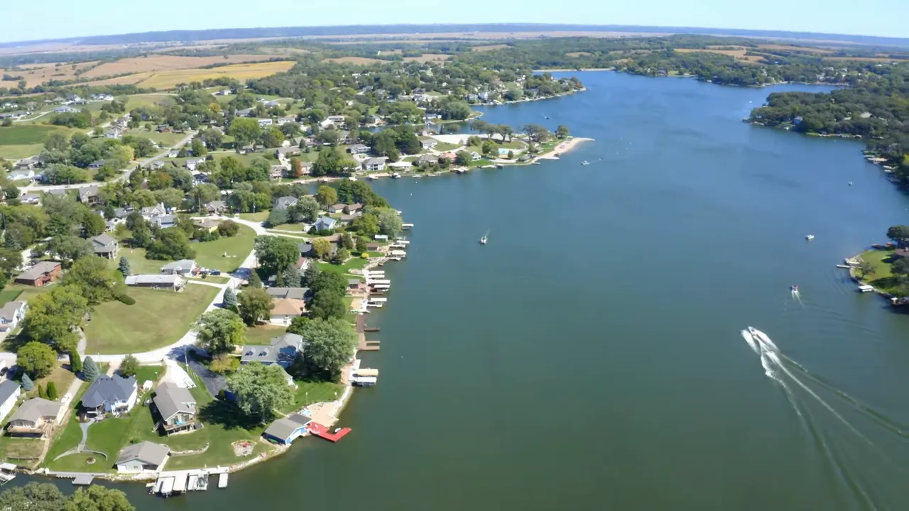 Aerial view of a lake with residential shoreline, docks, and boats