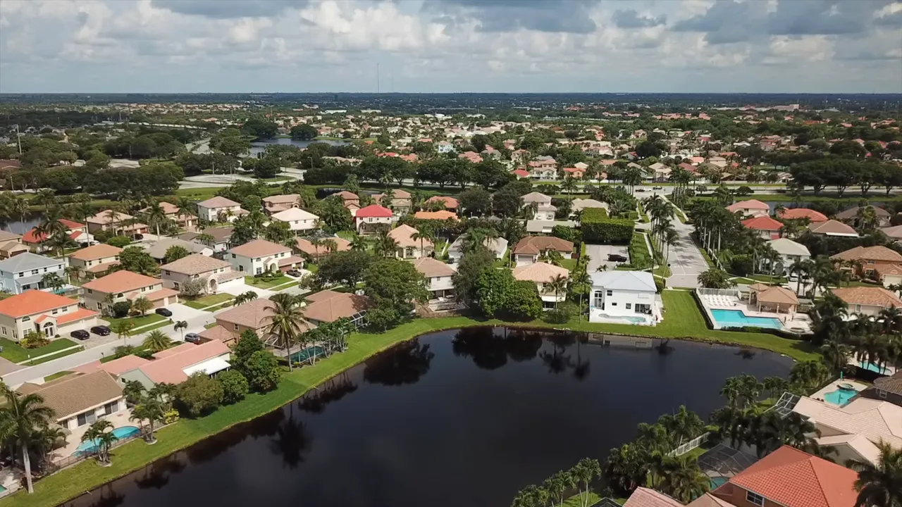 aerial view of Le Palais neighborhood in Boynton Beach with lake and single-family homes