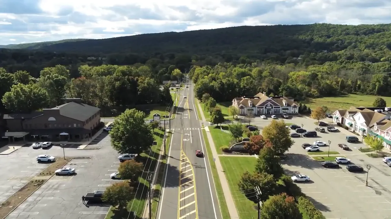 Road through Long Valley town center with parking lots and buildings on both sides