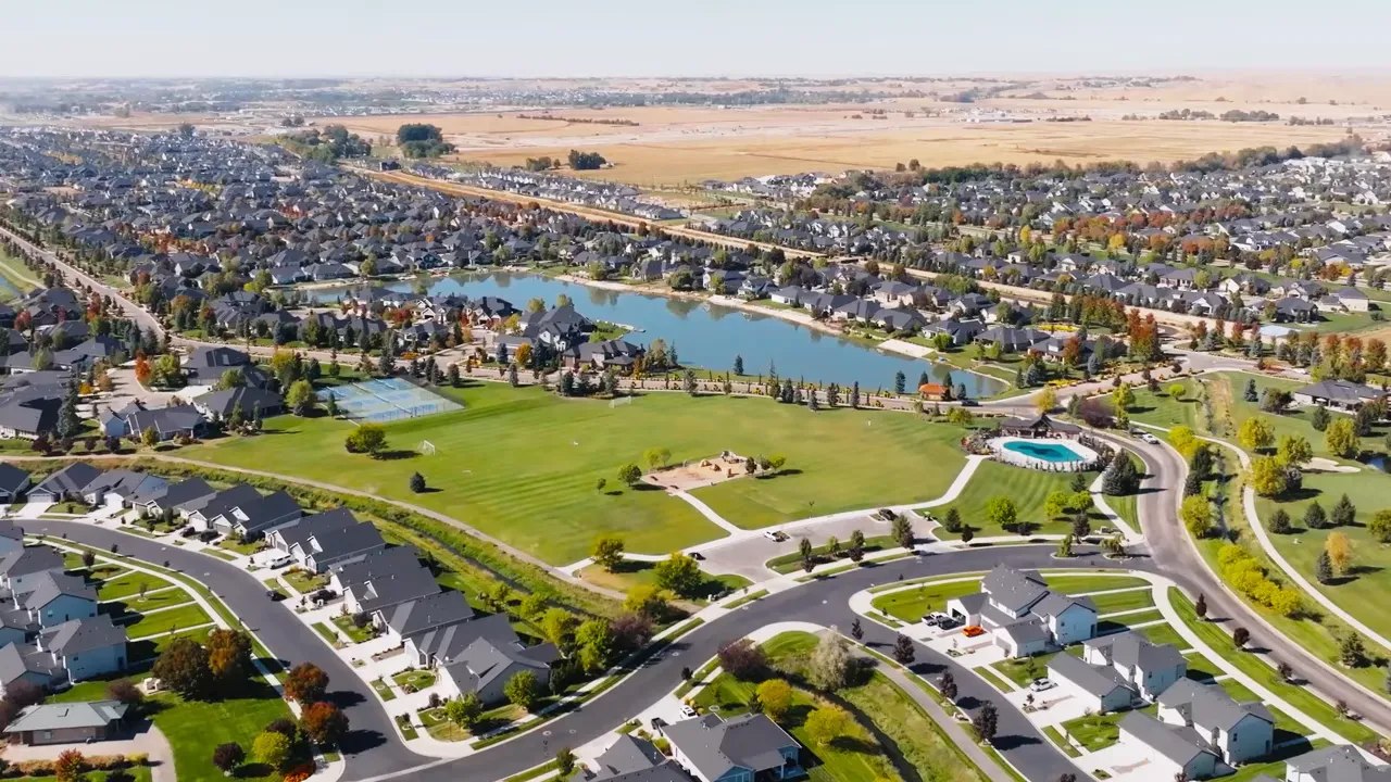 Aerial view of an upscale neighborhood around a lake and green space
