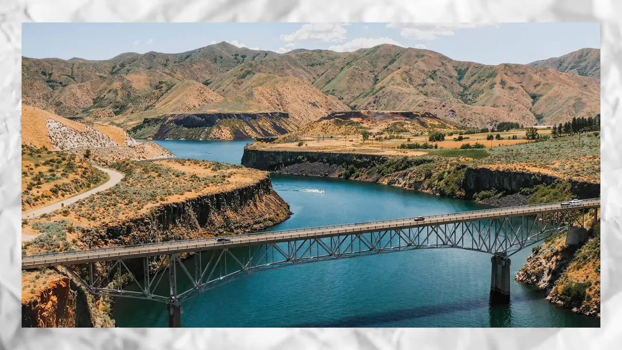 Bridge crossing blue water with dry hills in the background