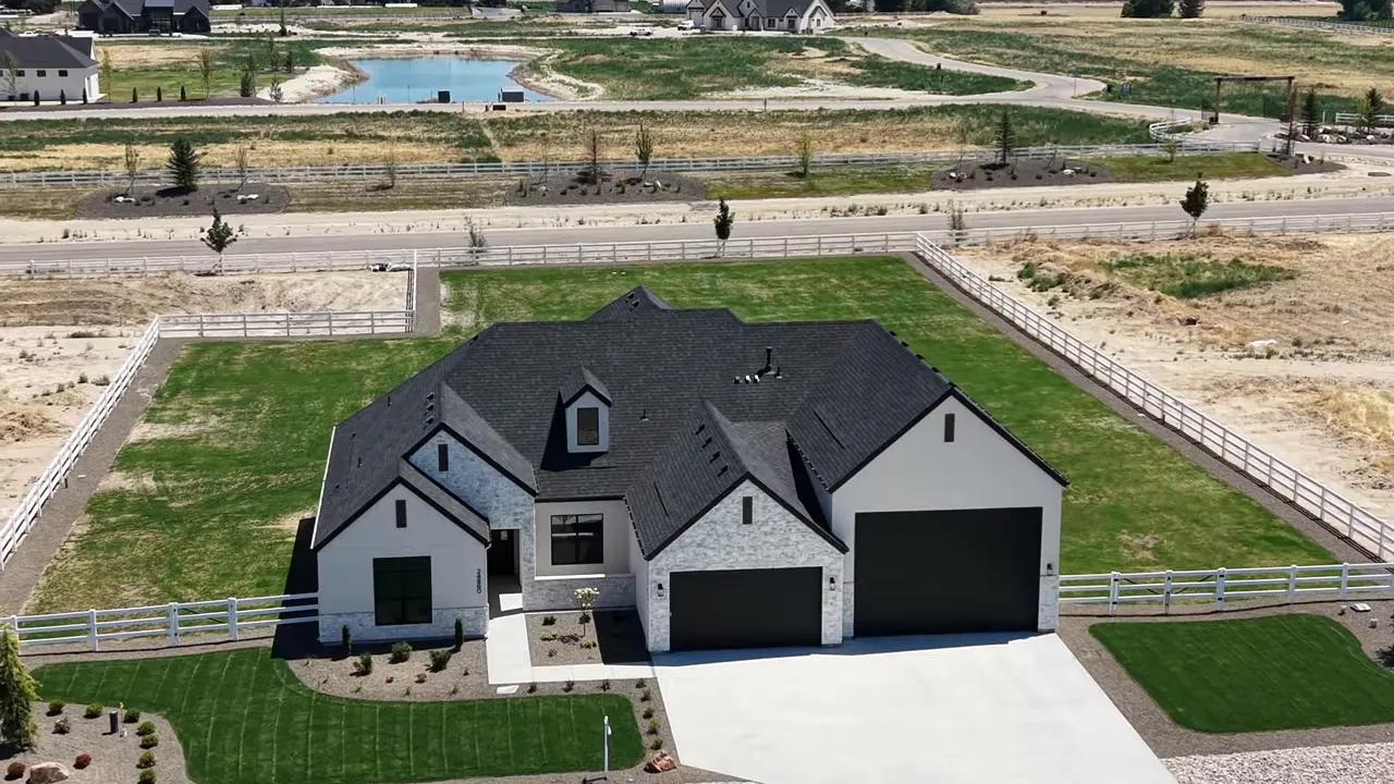 Aerial view of single level home with white fence and acreage lot