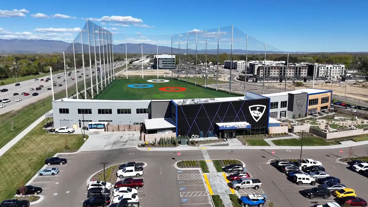 Aerial view of Topgolf facility near freeway and commercial buildings