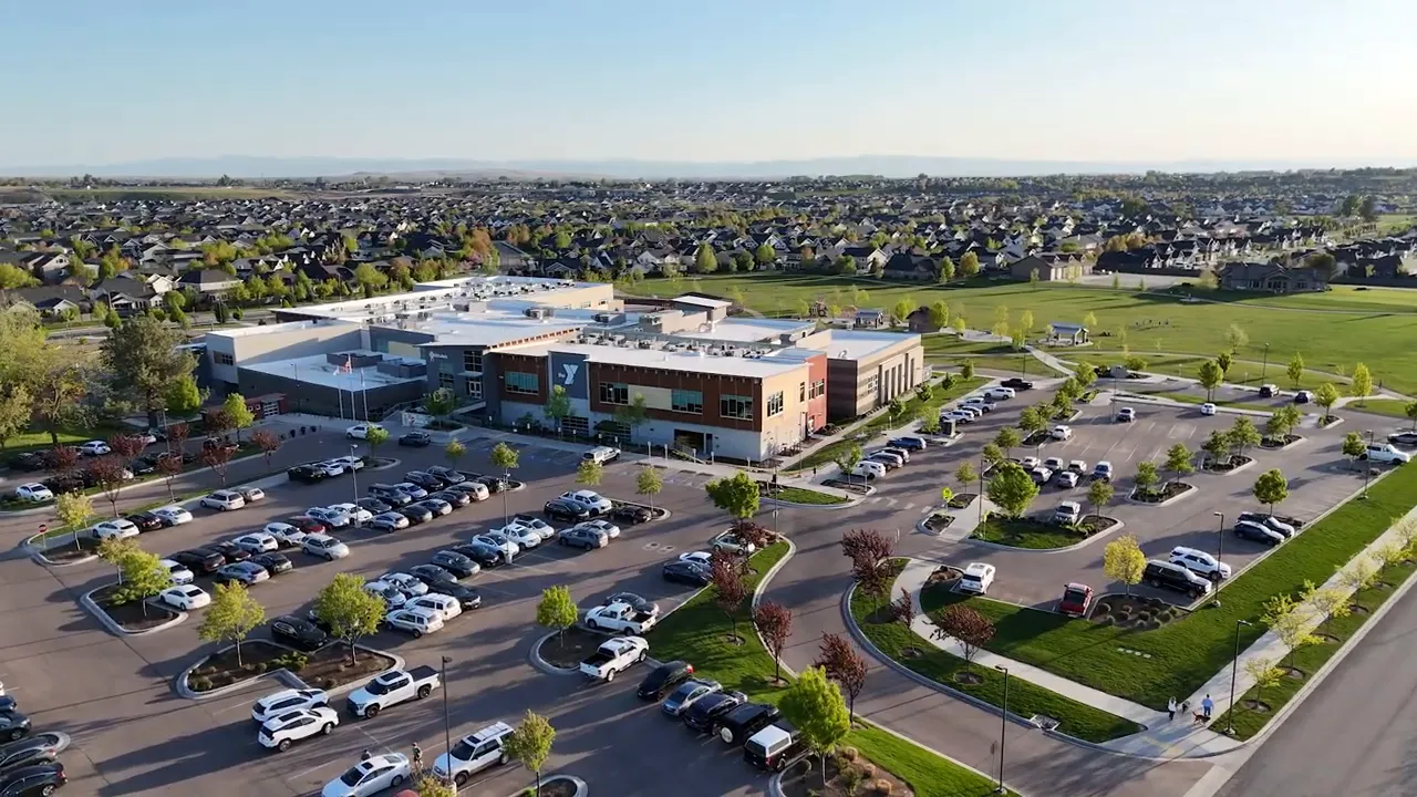 Aerial view of a large YMCA building, parking lots, and surrounding neighborhoods