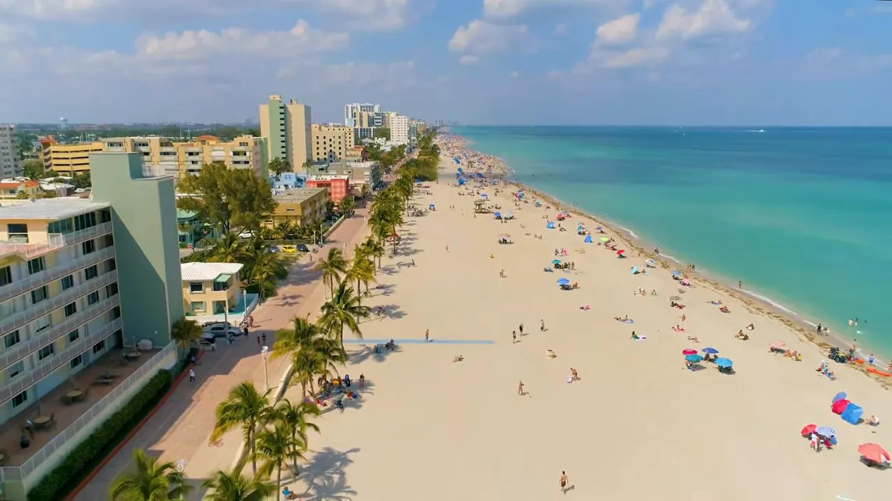 Aerial view looking down at Hollywood Beach coastline with hotels and umbrellas