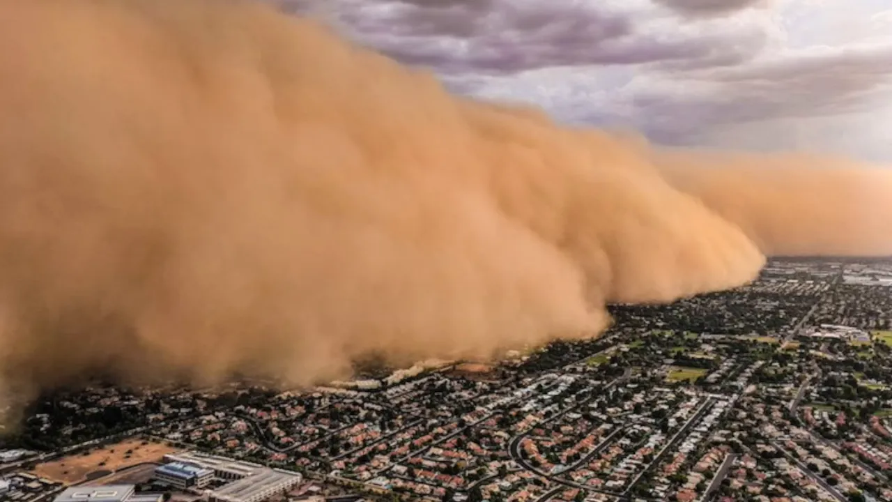 Massive brown wall of dust moving over a city