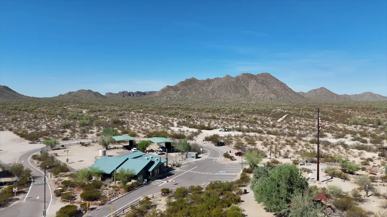 Aerial view of desert terrain and the San Tan Mountains under a clear blue sky