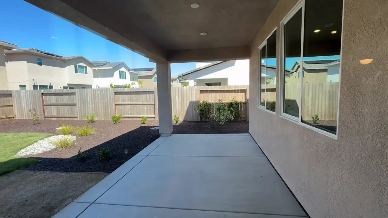 Covered patio with concrete flooring and backyard landscaping at Arbor Ranch in Elk Grove